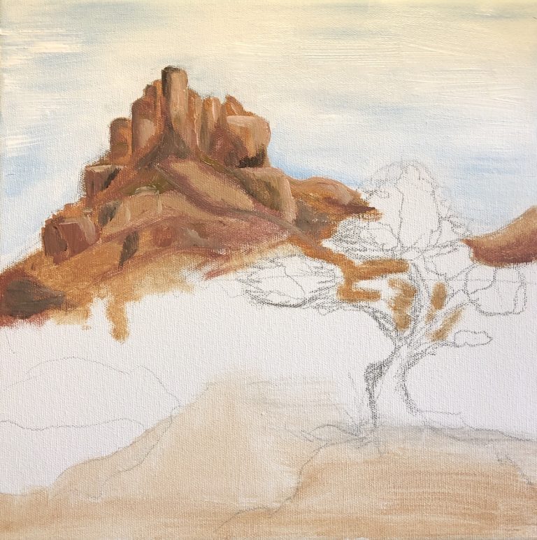 Incomplete painting of a tree perched in front of a mountain in the distance.